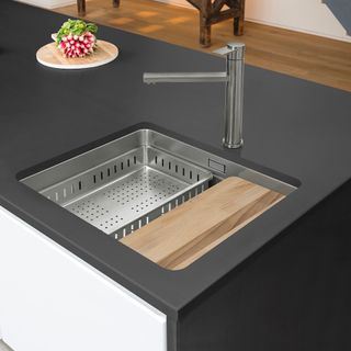 kitchen sink in black colour with draining rack and chopping board