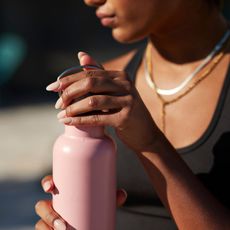 woman holding a pink water bottle