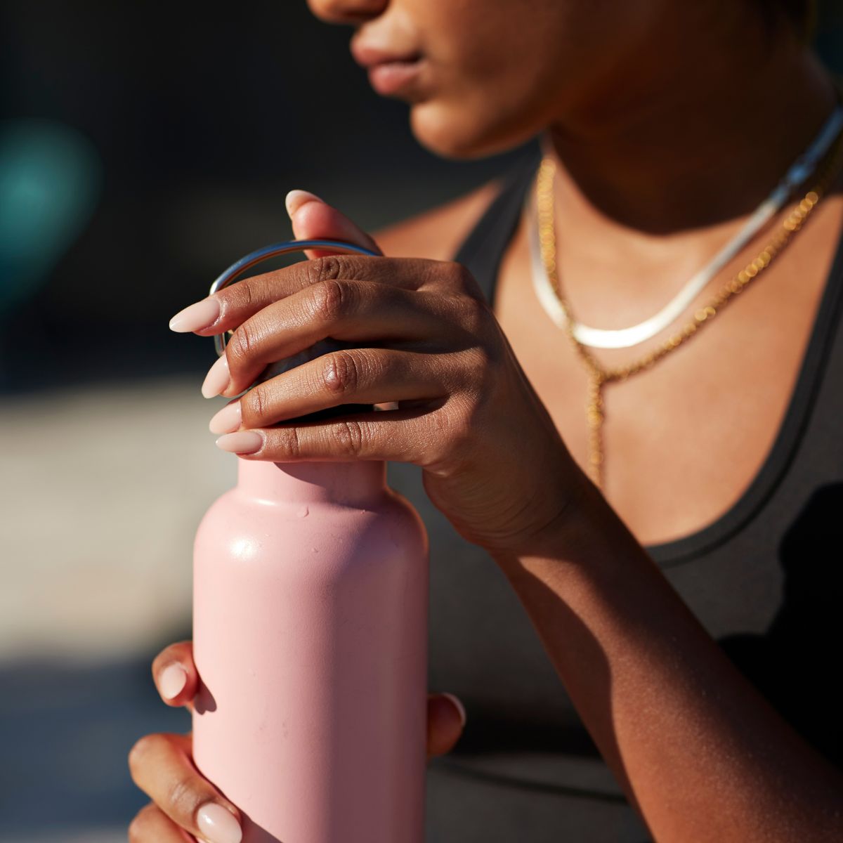woman holding a pink water bottle