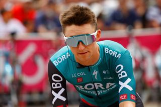 Bora-Hansgrohe Australian rider Jai Hindley goes to the teams presentation prior to the start of the 15th stage of the Giro dItalia 2022 cycling race 177 kilometers from Rivarolo Canavese Piedmont to Cogne Aosta Valley on May 22 2022 Photo by Luca Bettini AFP Photo by LUCA BETTINIAFP via Getty Images