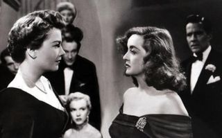 Anne Bancroft and Bette Davis facing each other angrily