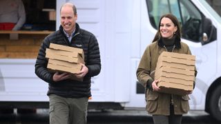 Prince William, Prince of Wales and Catherine, Princess of Wales gather pizza boxes from a pizza van at Dowlais Rugby Club during a 2 day visit to Wales on April 27, 2023 in Merthyr Tydfil, Wales. The Prince and Princes of Wales are visiting the country to celebrate the 60th anniversary of Central Beacons Mountain Rescue and to meet members of local communities.