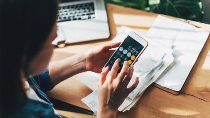 Close up of woman using phone calculator