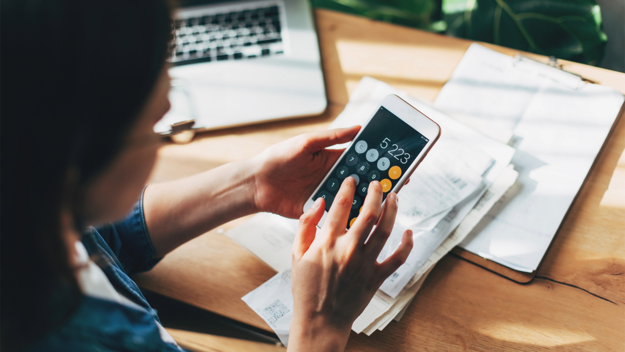 Close up of woman using phone calculator