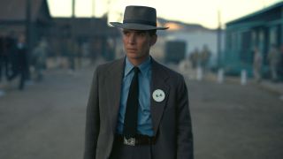 Cillian Murphy walks down a road at base camp in Oppenheimer.