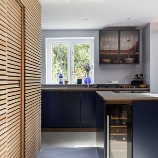 navy blue kitchen island with compact wine fridge