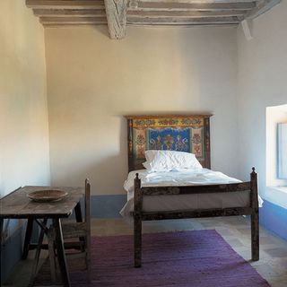 bedroom with old wooden cot and white mattress