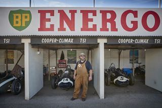 A mechanic looks towards the racetrack on day three of the Goodwood Revival Festival at Goodwood. Credit: Kiran Ridley/Getty Images