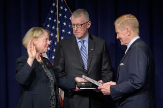 Former astronaut Pam Melroy is sworn in as the 15th NASA deputy administrator by NASA Administrator Bill Nelson, as her husband, Doug Hollett, holds their family Bible on June 21, 2021, at the Mary W. Jackson NASA Headquarters building in Washington, D.C.