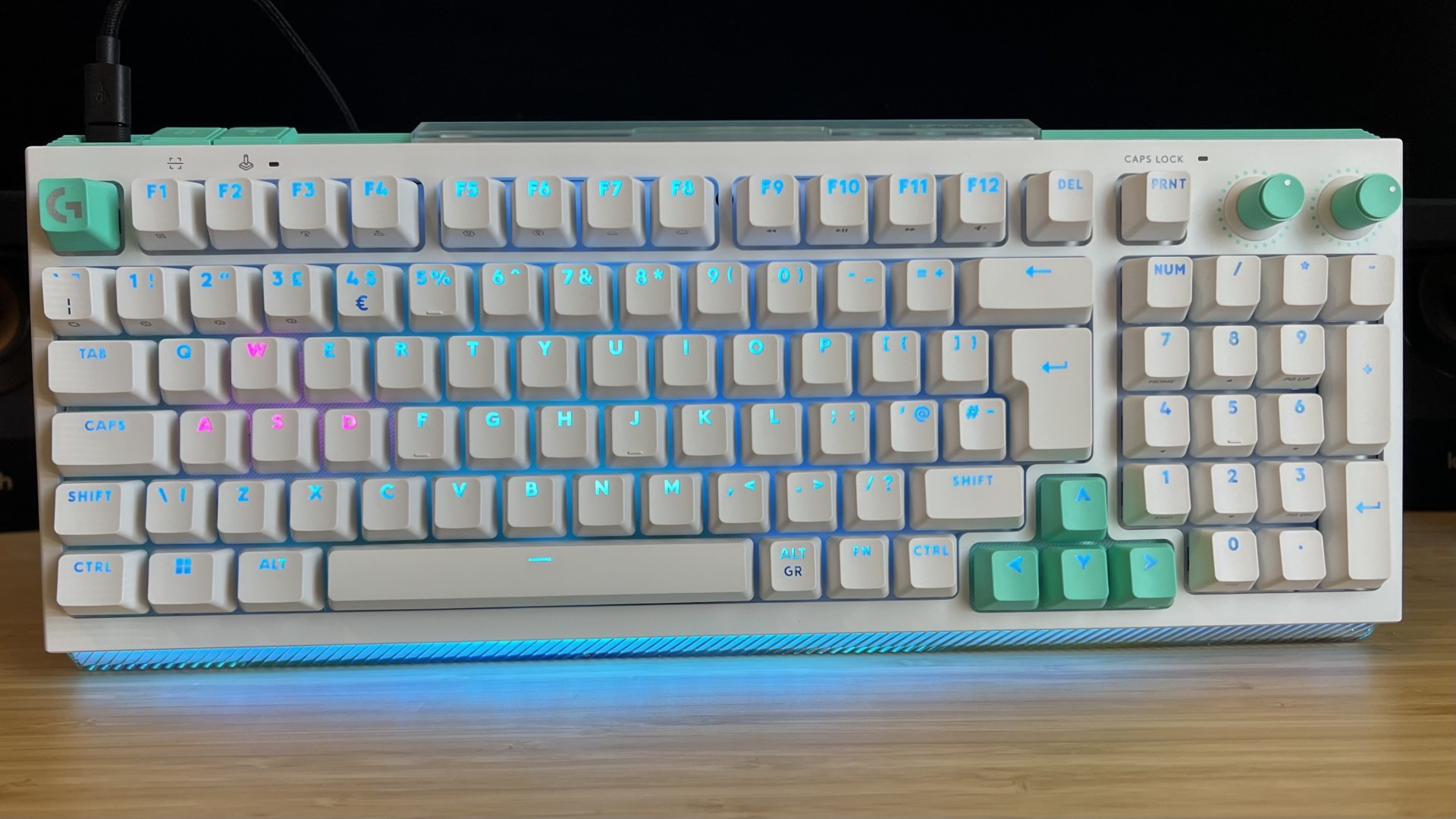 Logitech G512 X gaming keyboard with RGB lighting on on a wooden desk