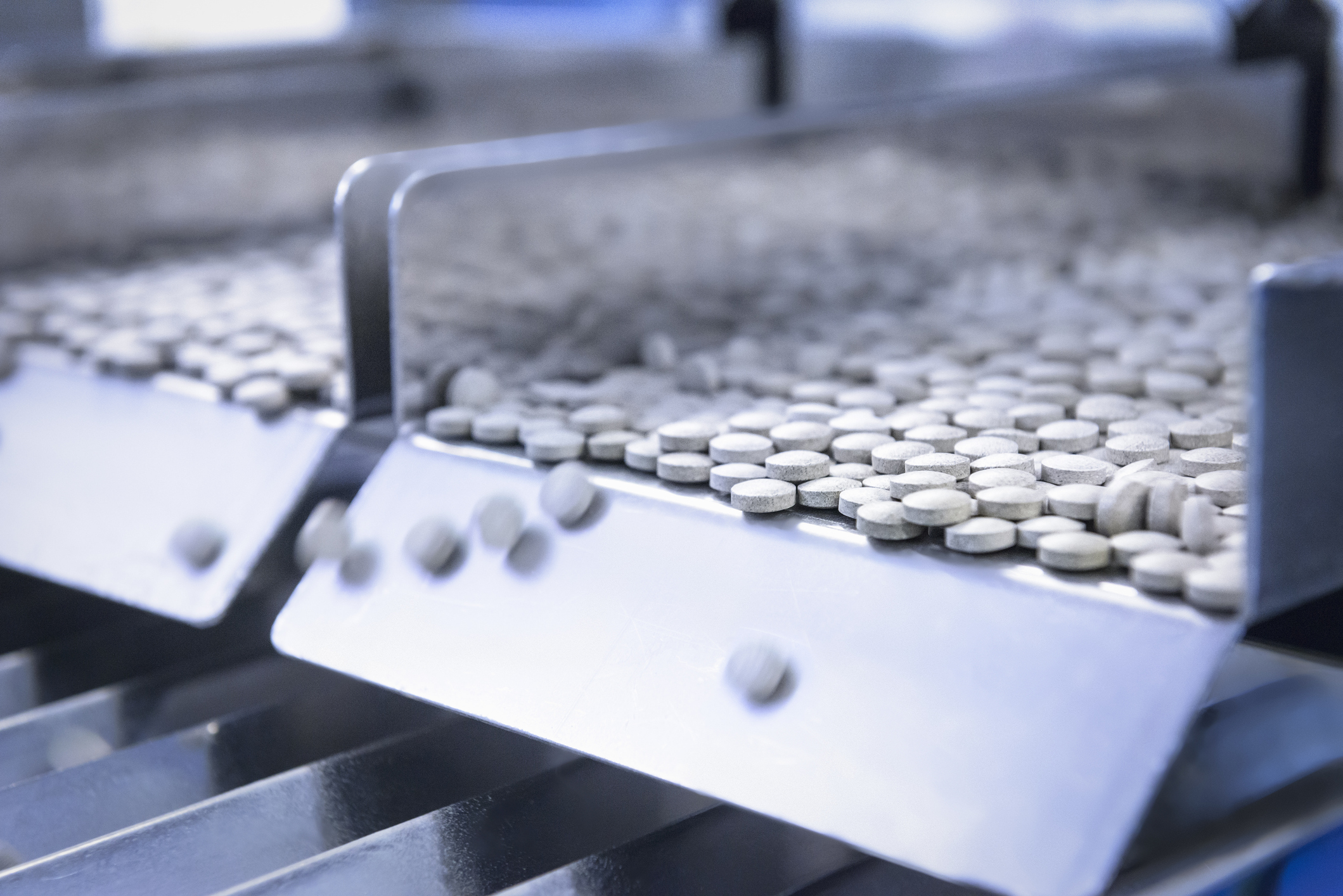 Close up of tablets in packing machine in pharmaceutical factory
