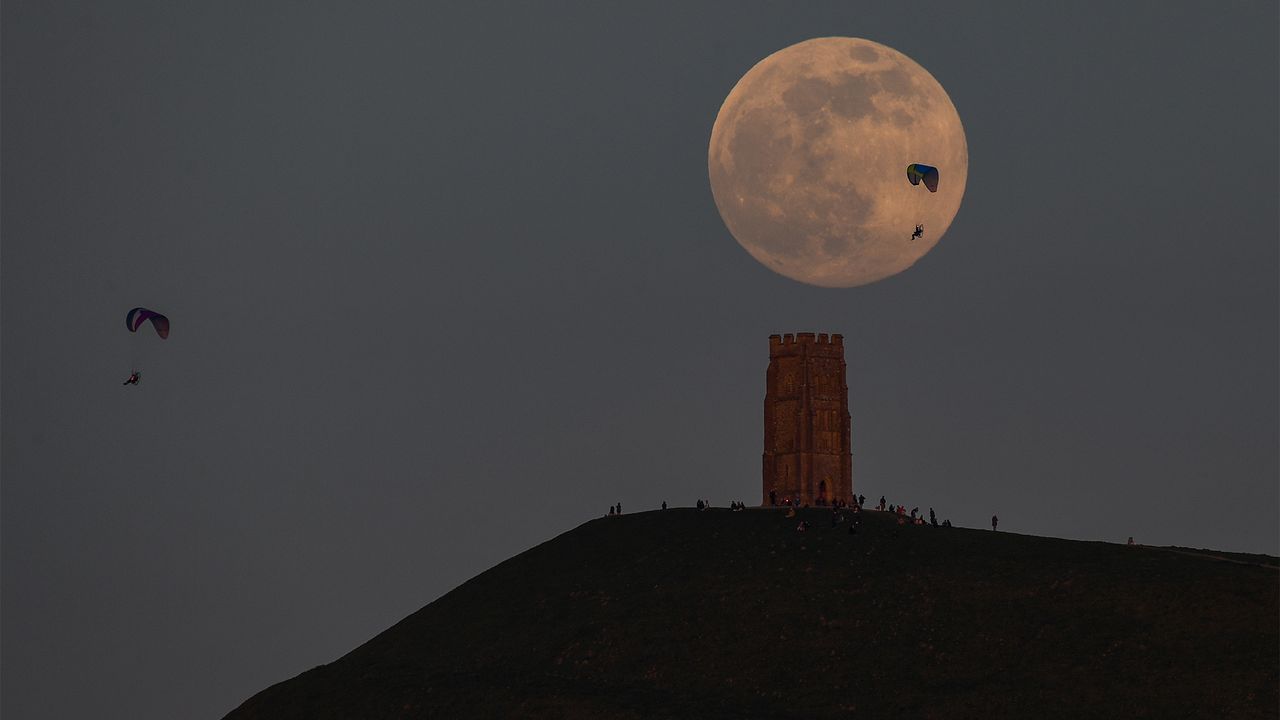 The Super Pink Moon rises in the night sky over Glastonbury, England, on April 26, 2021.
