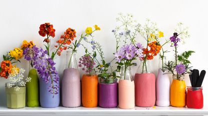 colourfully painted glass milk bottles filled with flowers