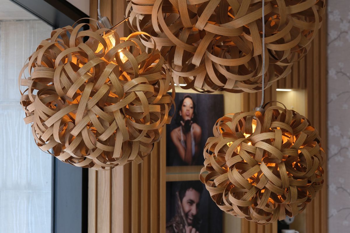 Three lights hanging from a ceiling in front of a photo