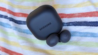 The Samsung Galaxy Buds 2 resting on multi-colored fabric