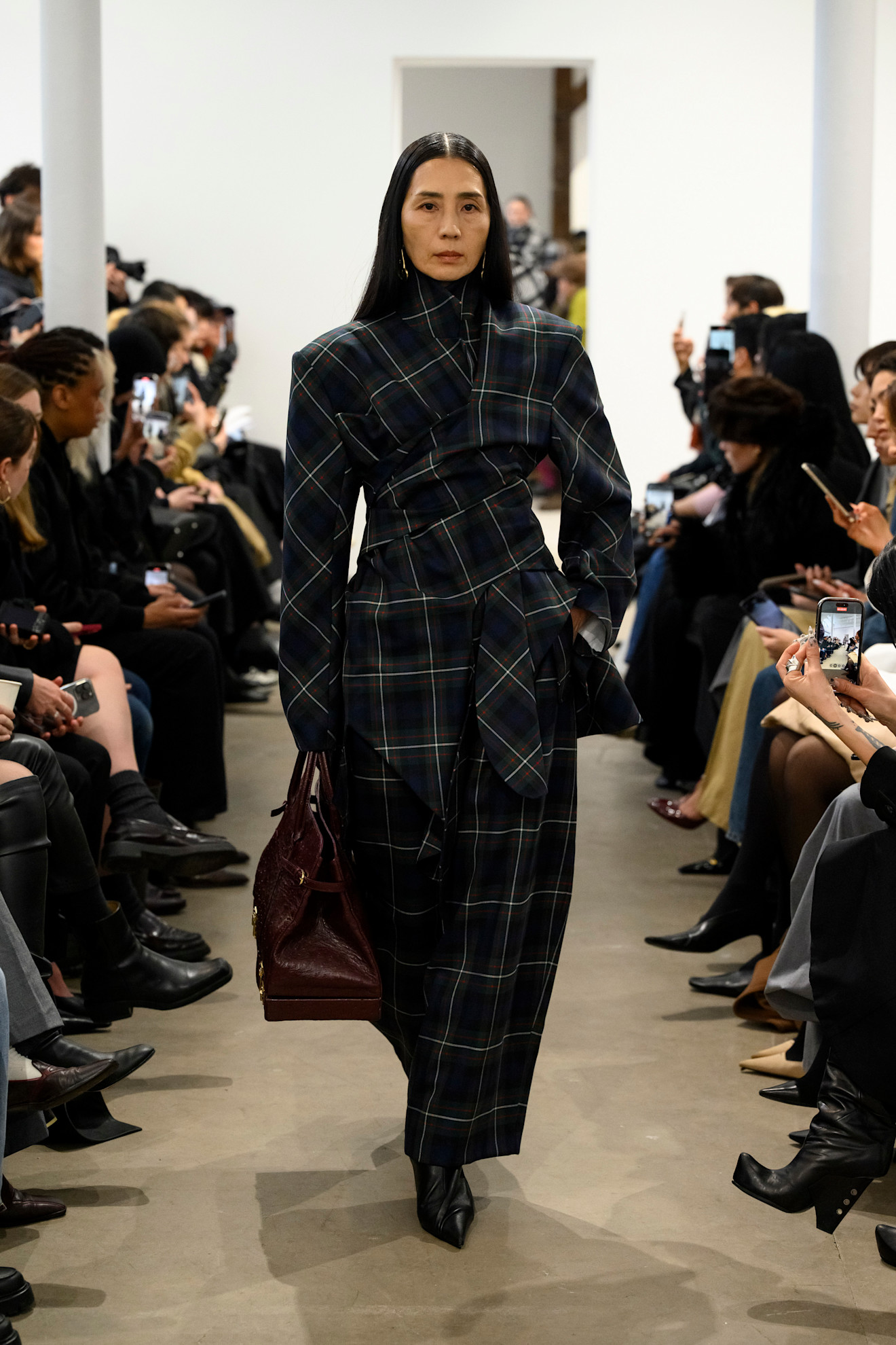 Photo of model on runway wearing checkered plaid maxi skirt.