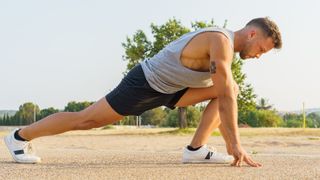 Man in runner&#039;s lunge during outdoor workout 