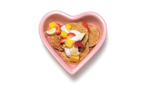 Pink heart shaped bowl filled with dog pancakes