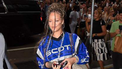 Rihanna wearing a blue jersey top, camo pants, metallic sneakers, and a Gucci tote in New York City July 2024