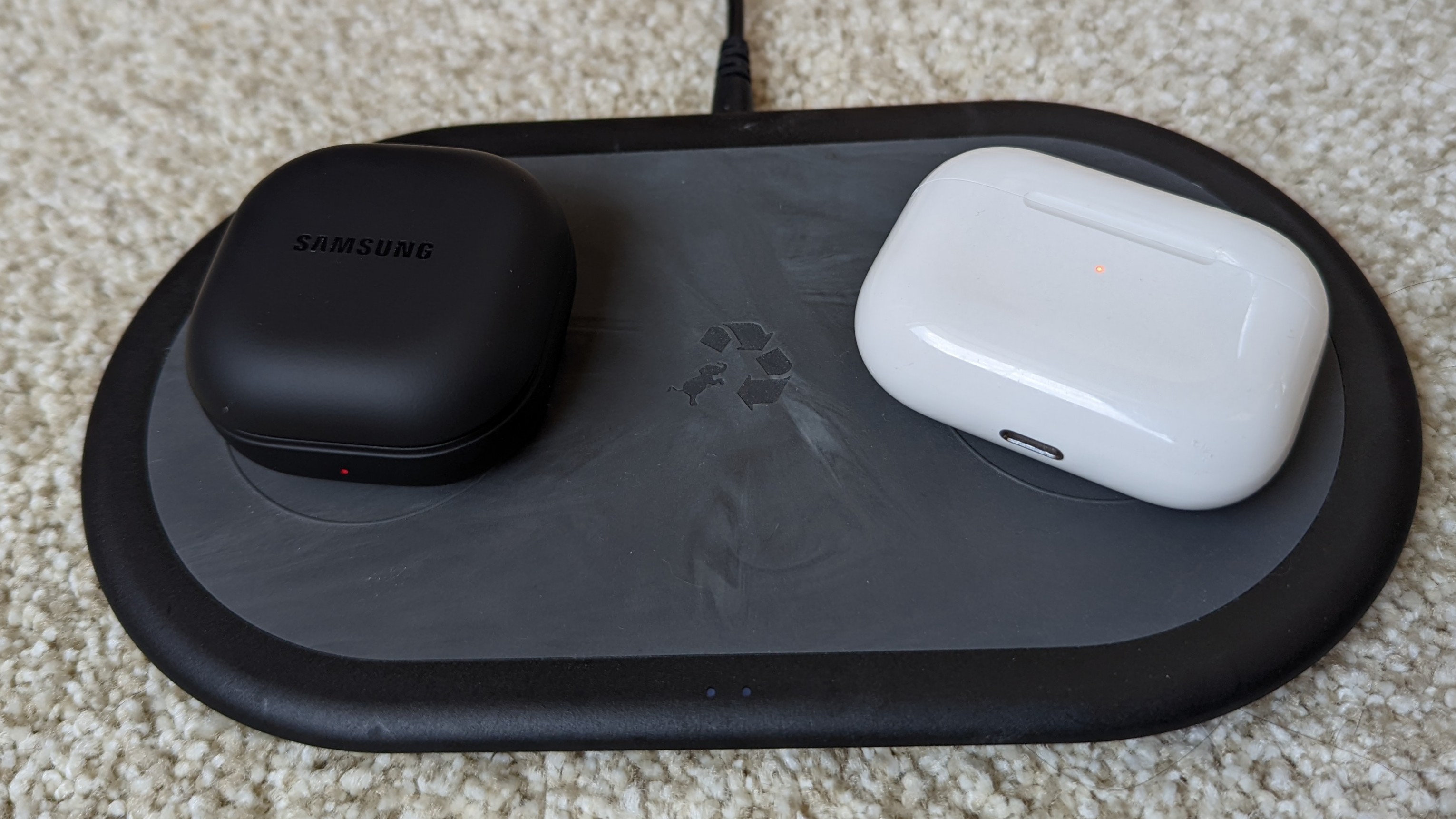 The Samsung Galaxy Buds 2 Pro and AirPods Pro charging cases sitting on a wireless charging pad