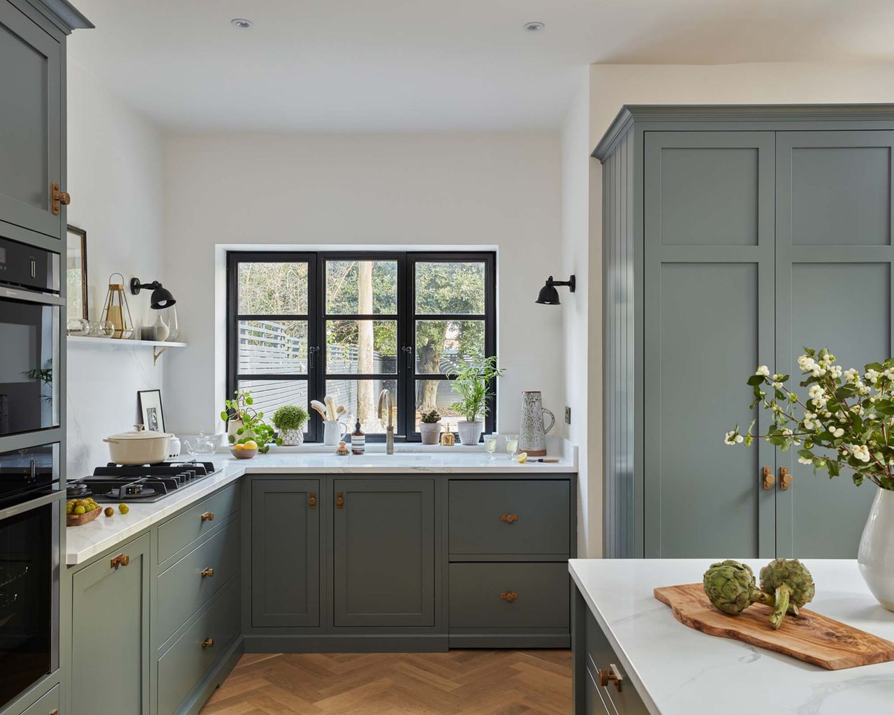 Modern blue kitchen with black framed window and island
