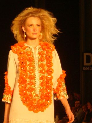 Model in orange dress with ruffled floral edging