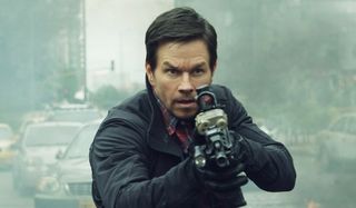 Mile 22 Mark Wahlberg making his way through a combat zone with a rifle