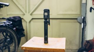 A Topeak Mountain 2Stage Digital bicycle pump in a garage