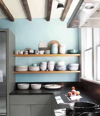 dark grey kitchen with light blue walls close up of wall shelves and cabinets
