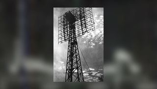 a black and white image of a radio antenna set against the clouds in the sky