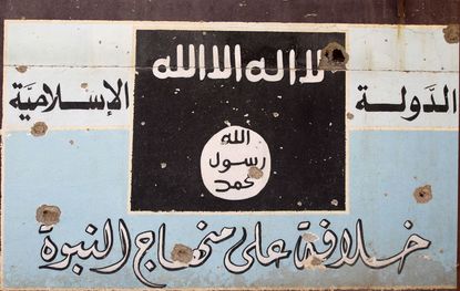 An ISIS mural with bullet holes.