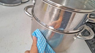 Cleaning stainless steel with olive oil on blue cloth