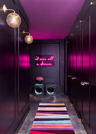 A room with black wardrobes and a wall with neon words