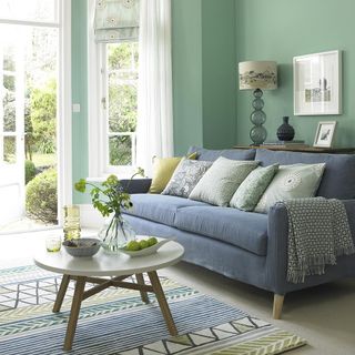 living room with blue sofa and coffee table and green wall