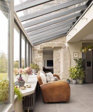 grey small conservatory with sofa and exposed stone wall