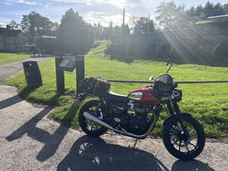 A photograph of a motorbike against a sunny, scenic background