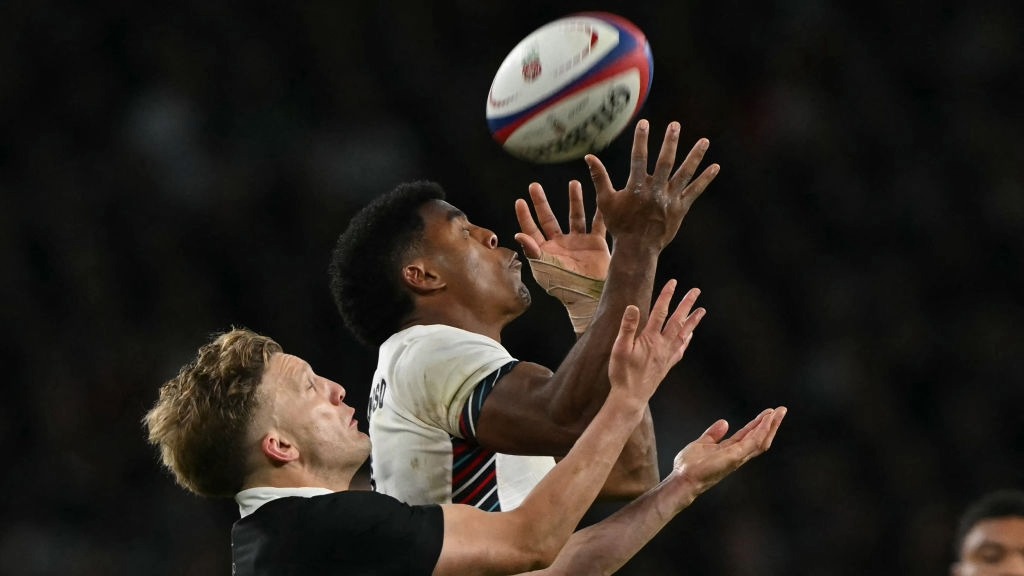 England winger Immanuel Feyi-Waboso and New Zealand's Damian McKenzie contest a high ball during the teams' 2024 Autumn International fixture at Twickenham.