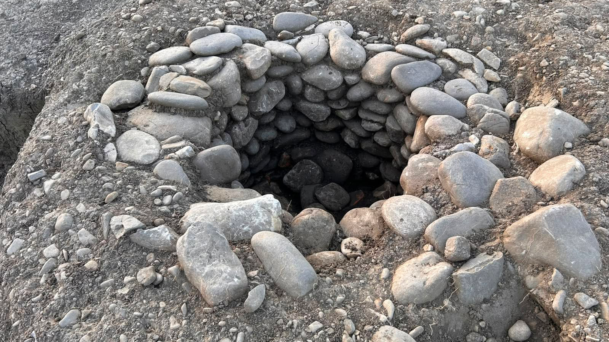 A stone-line well in the ground