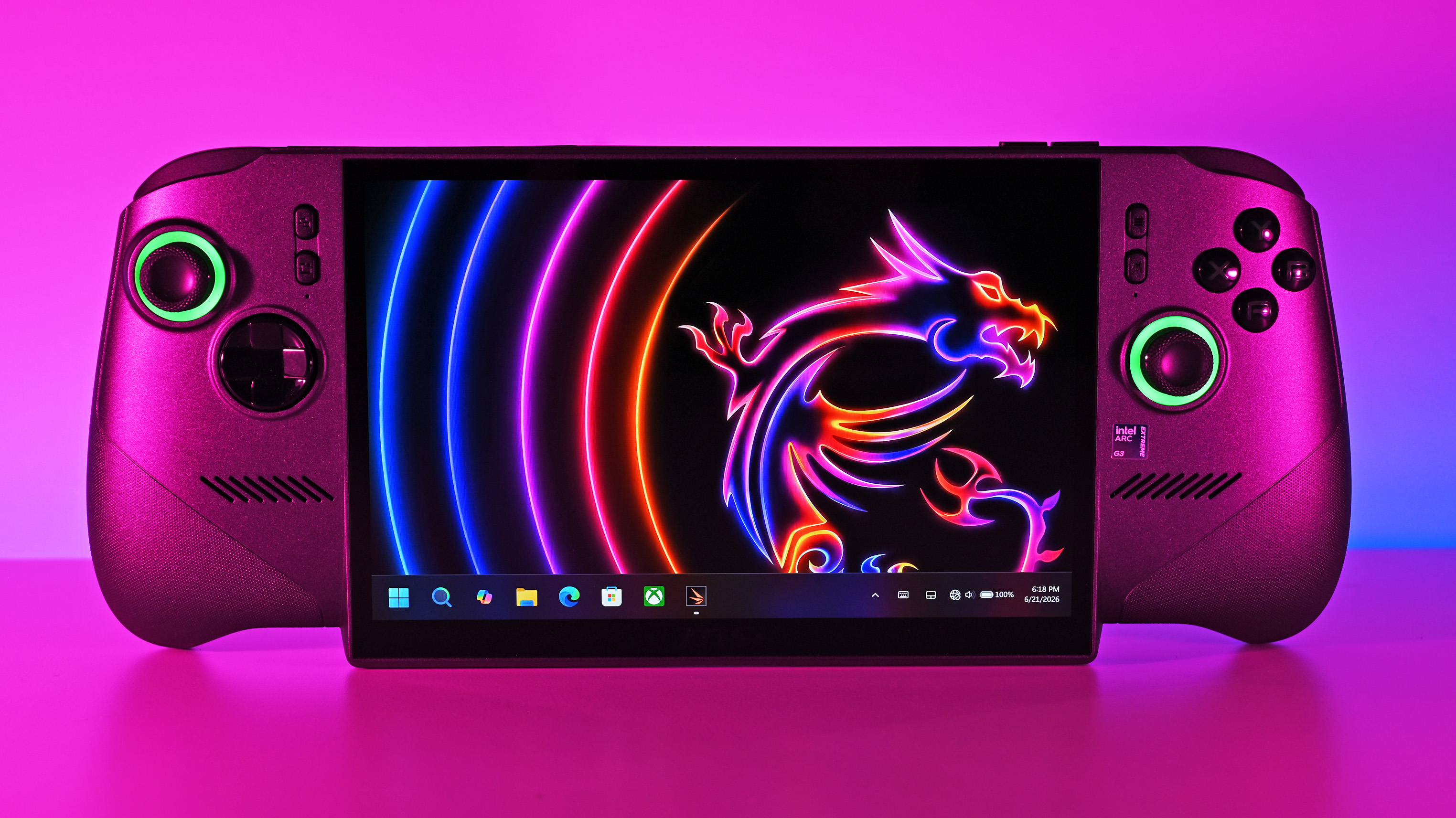 Front shot of the MSI Claw 8 EX AI+ under vibrant pink lighting, displaying the Windows 11 taskbar and a neon dragon wallpaper on its large screen.
