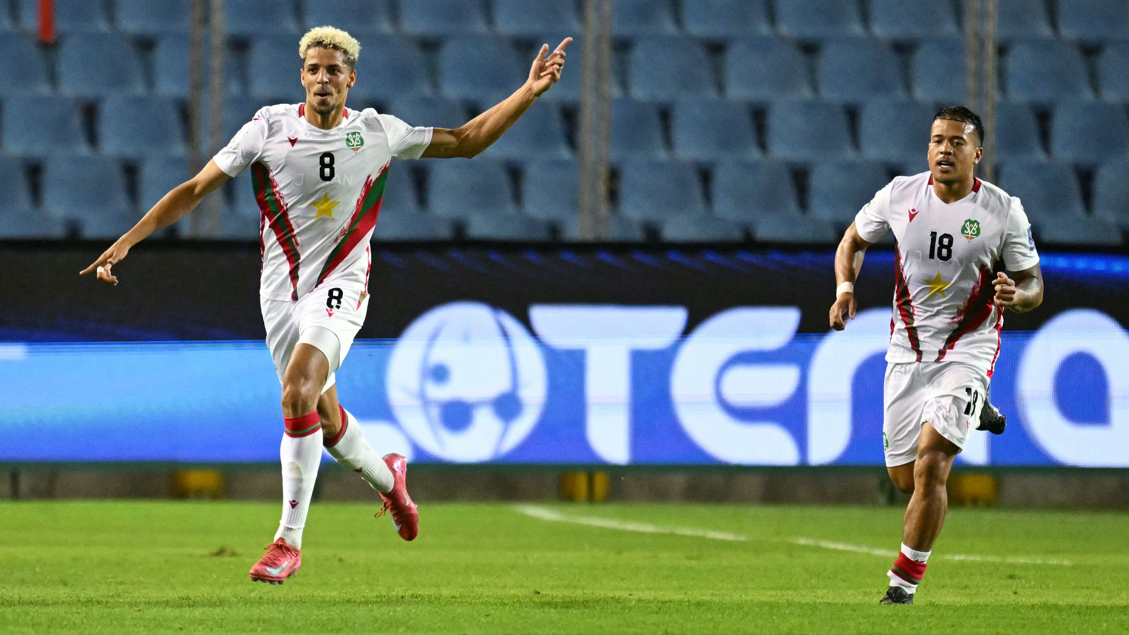 Suriname's midfielder #08 Justin Lonwijk (L) celebrates next to teammate midfielder #18 Jayden Turfkruier (R) after scoring his team's first goal during the 2026 FIFA World Cup Concacaf qualifier football match between El Salvador and Suriname at the Cuscatlan stadium in San Salvador on June 10, 2025.
