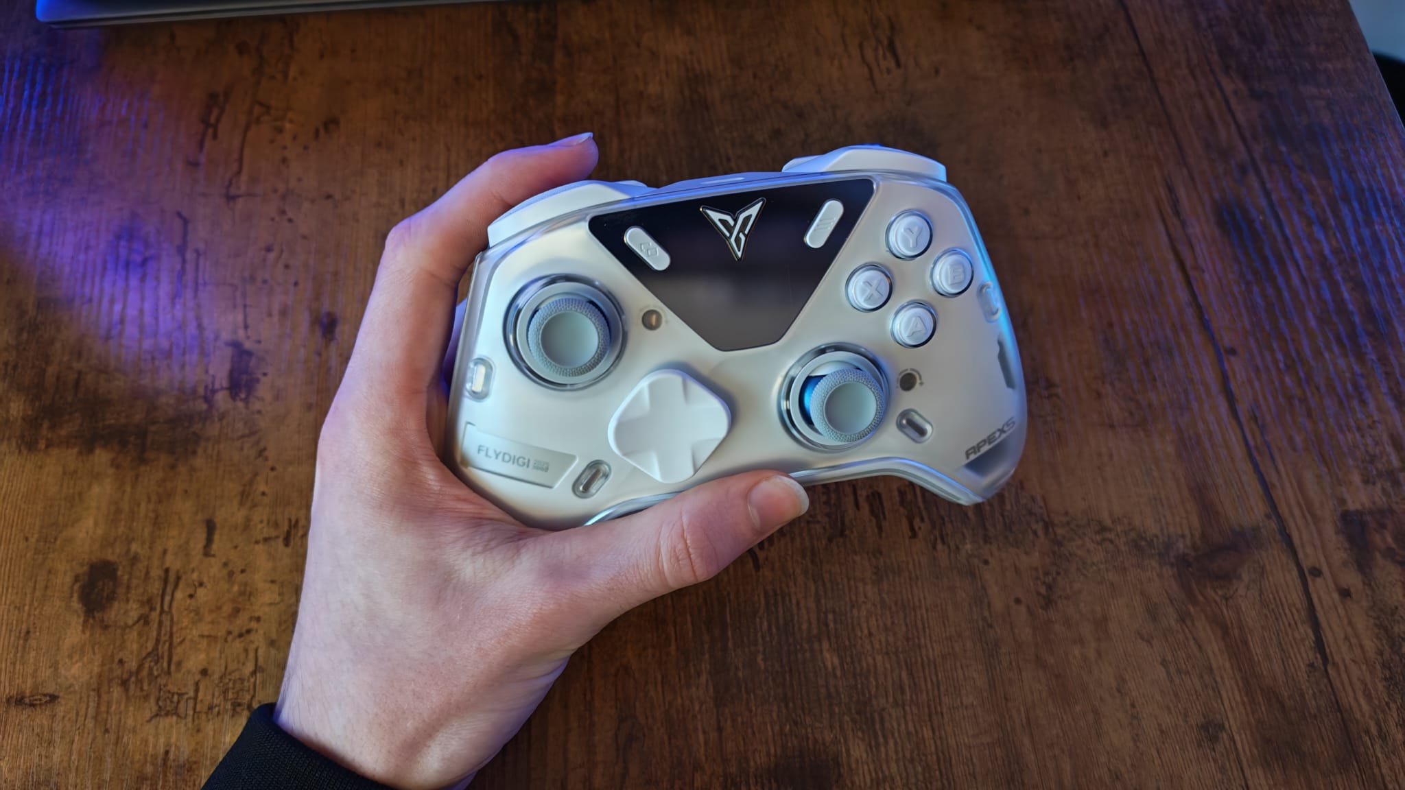 A reviewer holding the Flydigi Apex 5