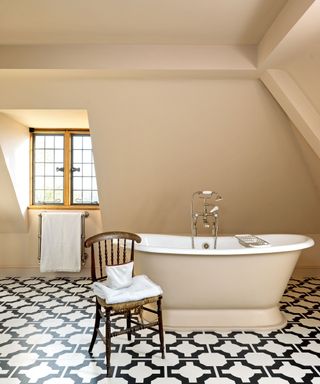 Neutral bathroom with patterned vinyl flooring and cream rolltop bath in Georgian style Cotswolds newbuild country house