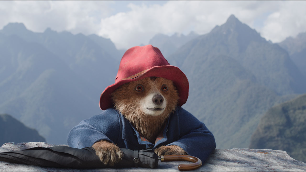 Paddington holding an umbrella after climbing a cliff in Paddington in Peru