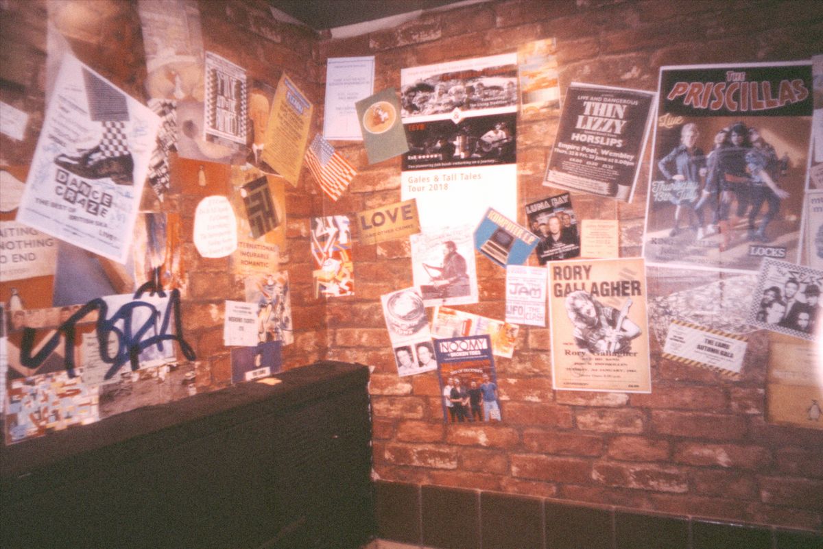 Grainy photo of flyers at a music venue, taken with the Flashback ONE35 redisposable digital camera