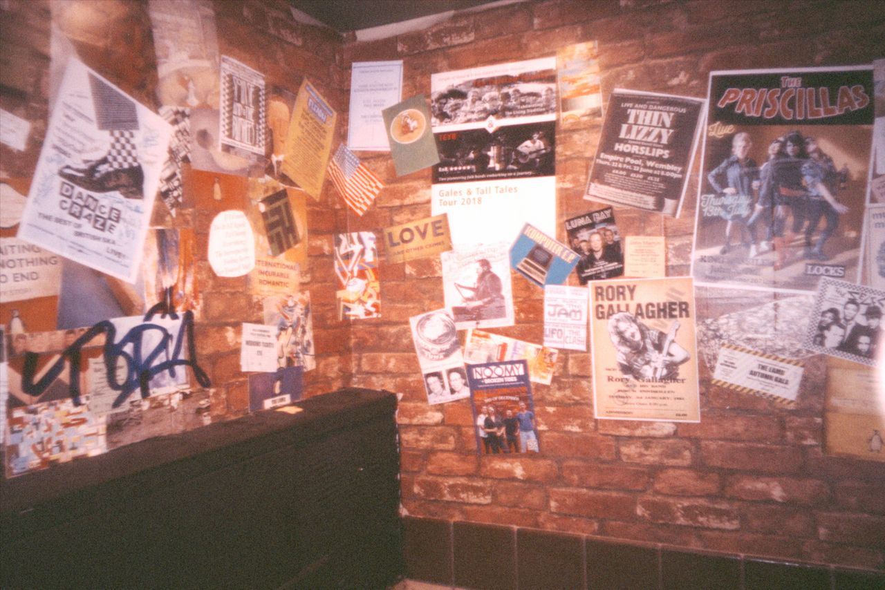 Grainy photo of flyers at a music venue, taken with the Flashback ONE35 redisposable digital camera