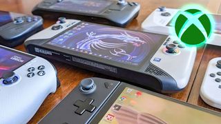 Several Windows handheld gaming PCs laying down on a table. An Xbox logo is in the upper right corner of the image. 