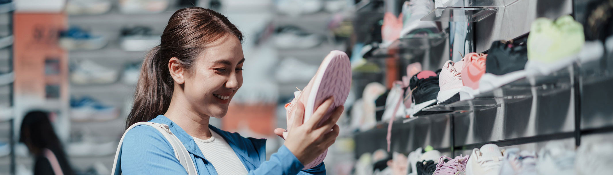 A picture of a young woman shopping for running shoes in a store