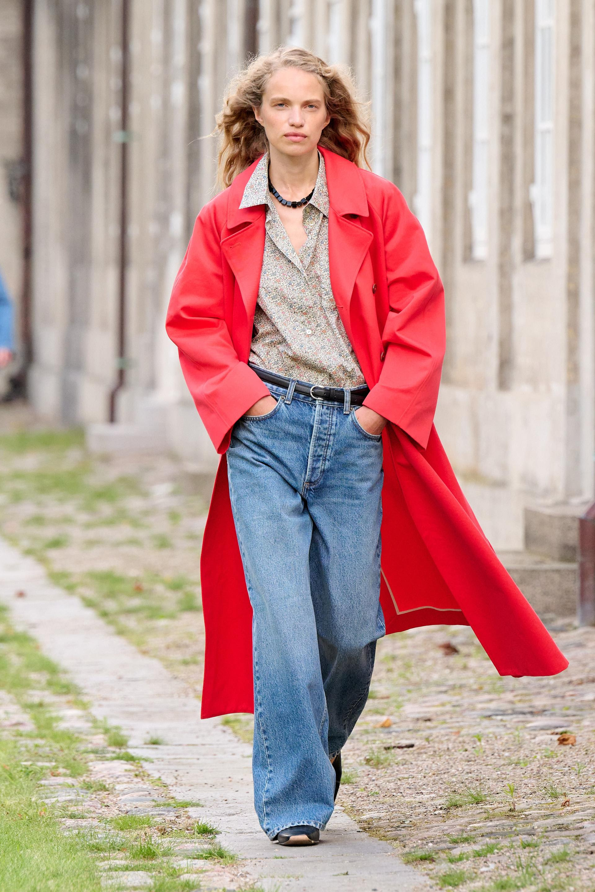 a model on the Skall Studio runway in a red trench coat