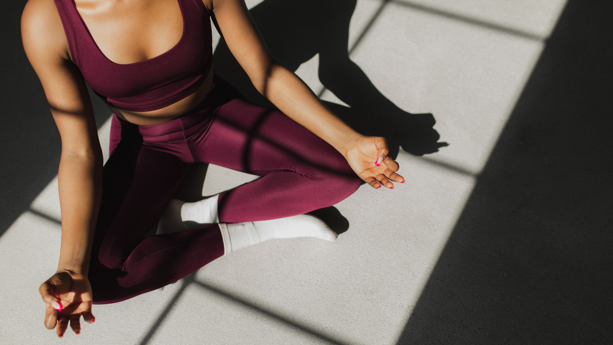 How to balance your hormones: A woman doing yoga at home in the sunshine