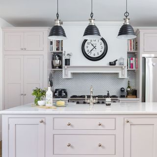 Pale pink painted kitchen with marble worktop in Georgian home